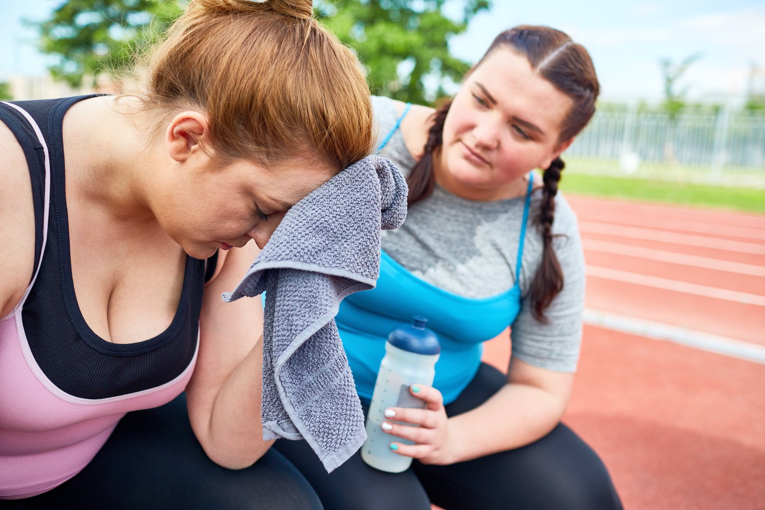 A girl sharing with her friend tired after running